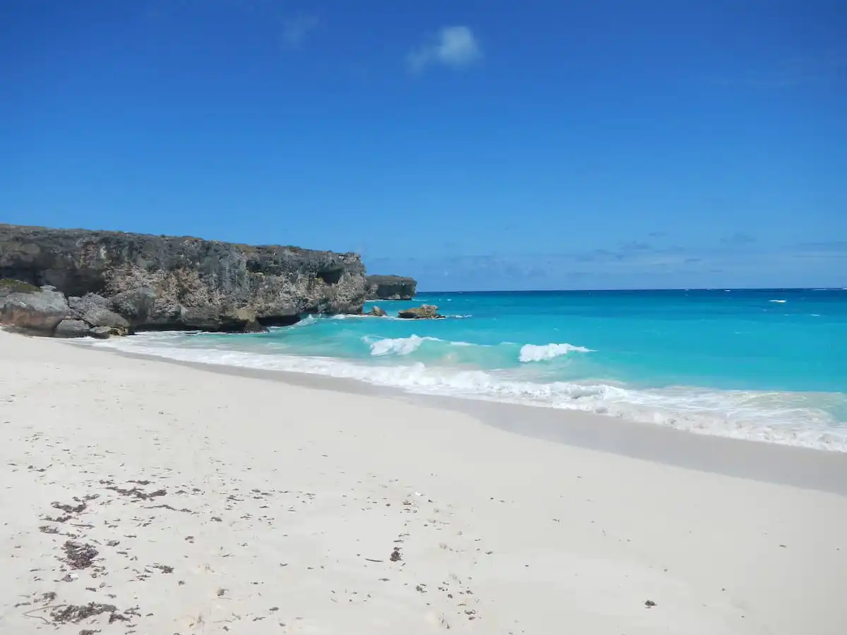 Blue waters amd skies at Bottoms Bay with cliffs in background