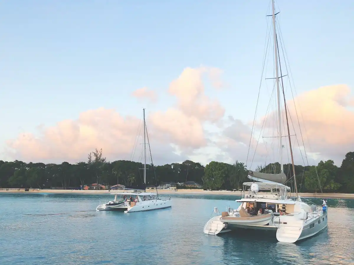 Two catamarans in the blue waters at a beach in Barbados
