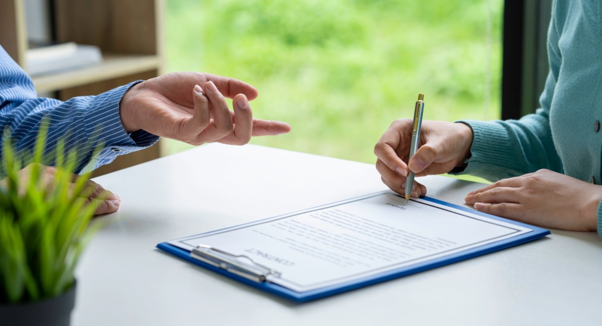 Property buyer signing legal documents with advisor during Barbados real estate purchase