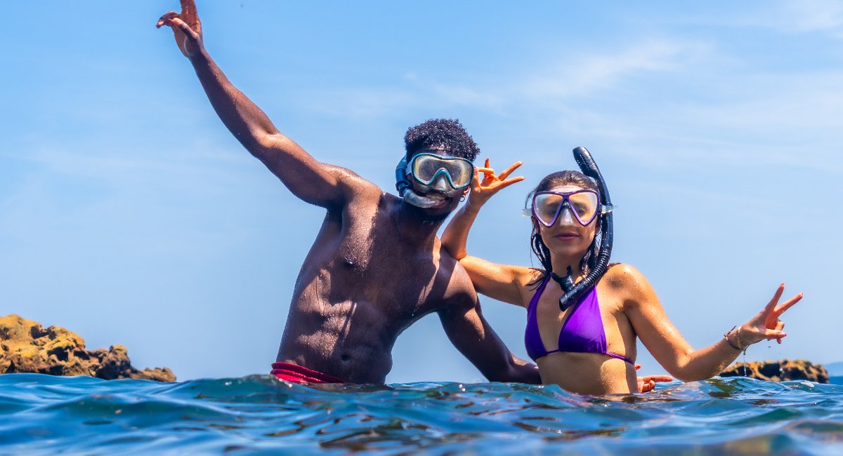 young couple posing as they snorkel in caribbean waters