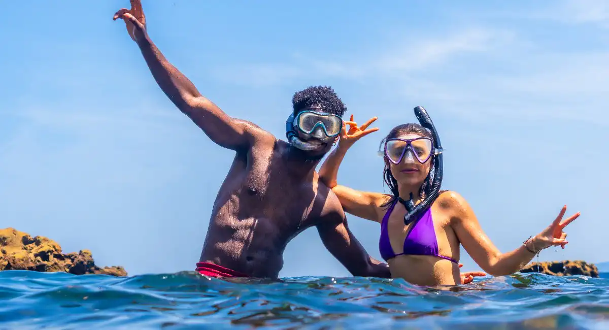 young couple posing as they snorkel in caribbean waters