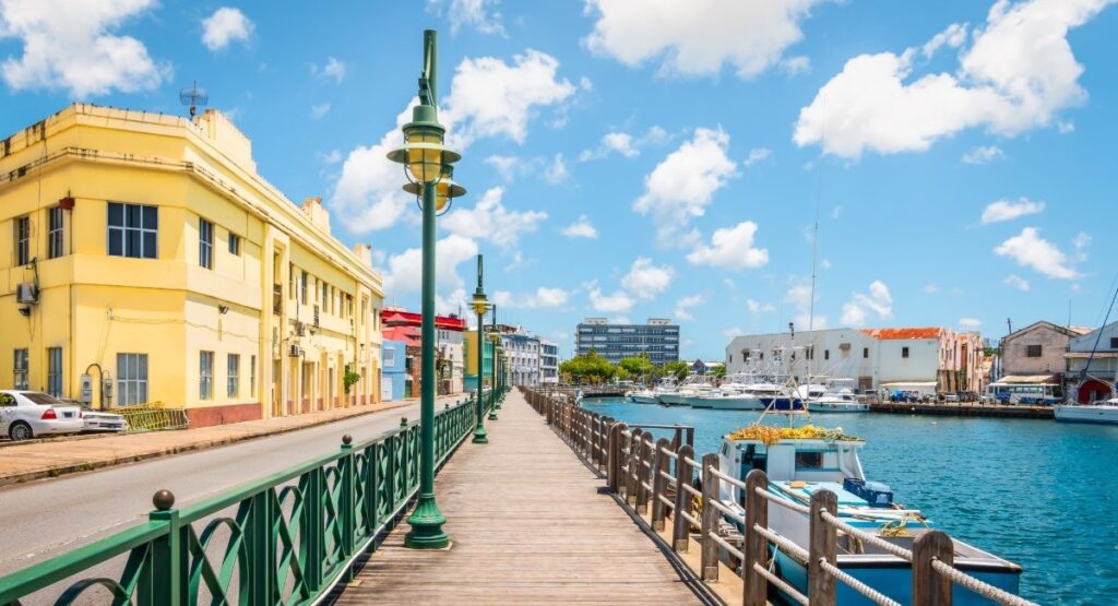 Historic Bridgetown waterfront boardwalk with colonial yellow buildings and marina showing Barbados capital city attractions for digital nomads and remote workers