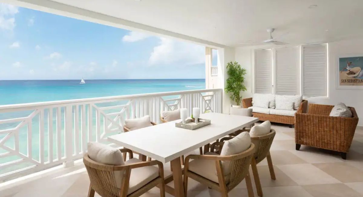 Ocean view covered patio of a luxury property in Barbados with sweeping view of the clear water and a boat in the distance